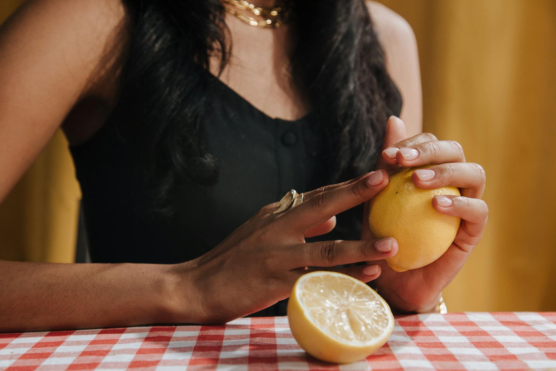 Hand holding a Lemon vibrator against a minimalist purple backdrop, representing restored sensation and modern pleasure