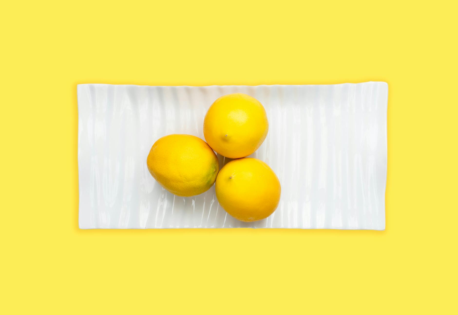 A yellow silicone vibrator surrounded by peeled bananas on a yellow background, symbolizing fresh pleasure