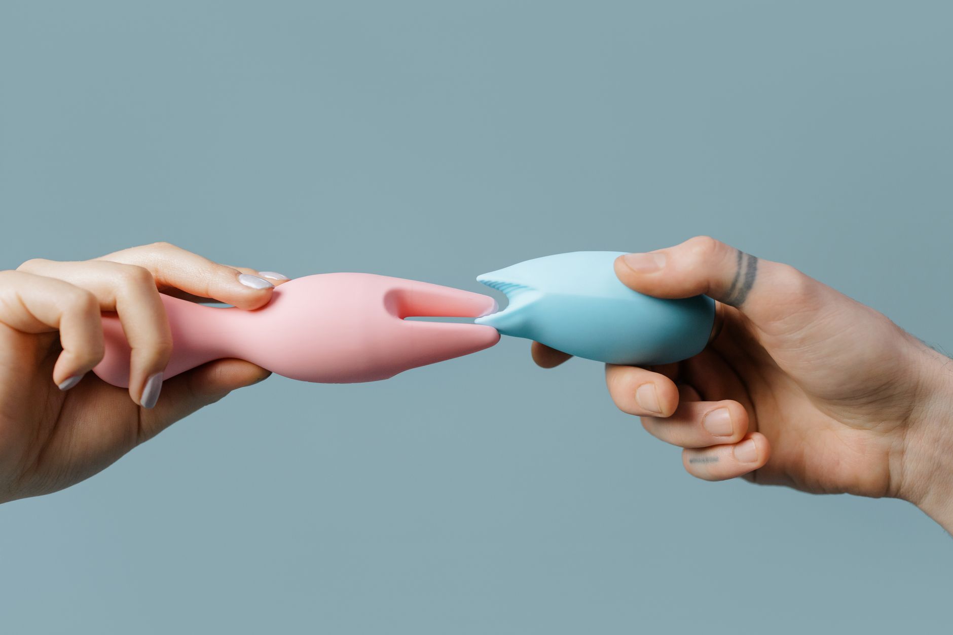 Woman with eyeglasses thoughtfully holding a pink vibrator