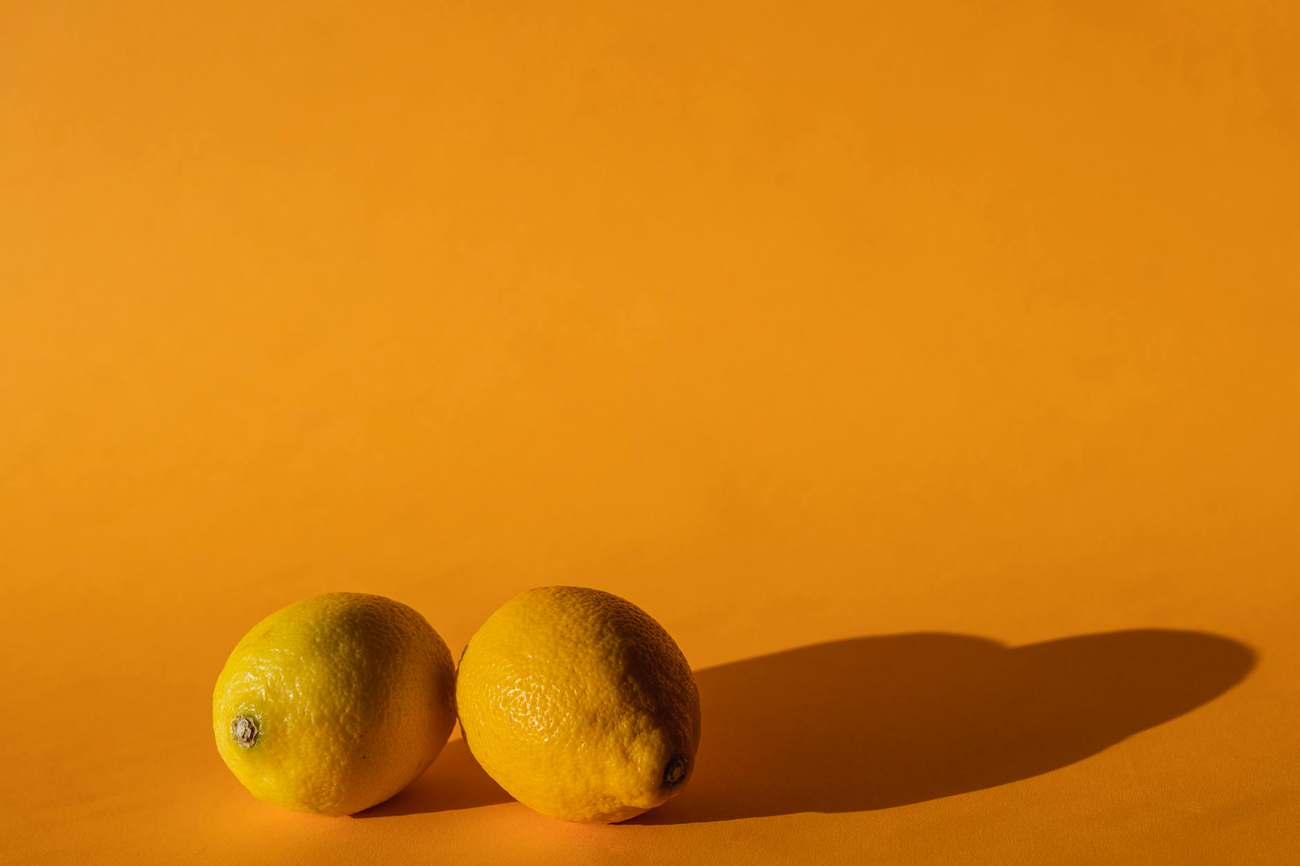Fresh lemons on a bright yellow background, symbolizing renewed connection and vitality